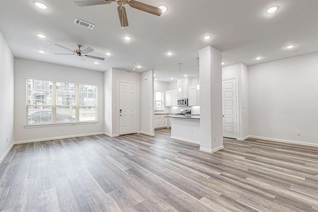 unfurnished living room with ceiling fan and light hardwood / wood-style flooring