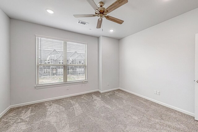 spare room featuring light colored carpet and ceiling fan