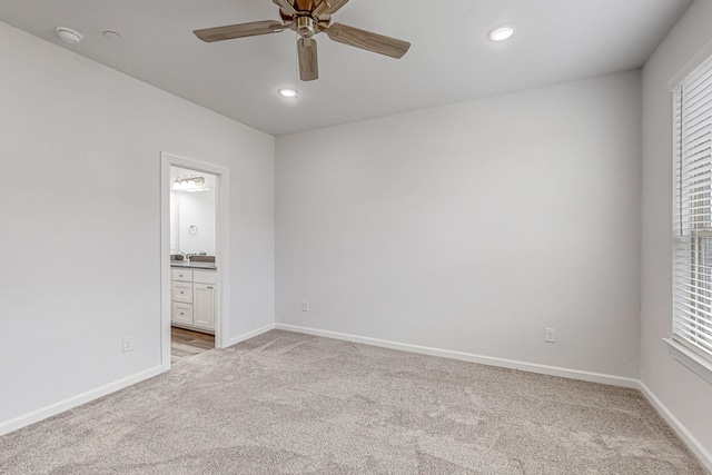 empty room with ceiling fan, light colored carpet, and a healthy amount of sunlight