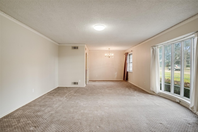 carpeted spare room with ornamental molding, a textured ceiling, and a notable chandelier