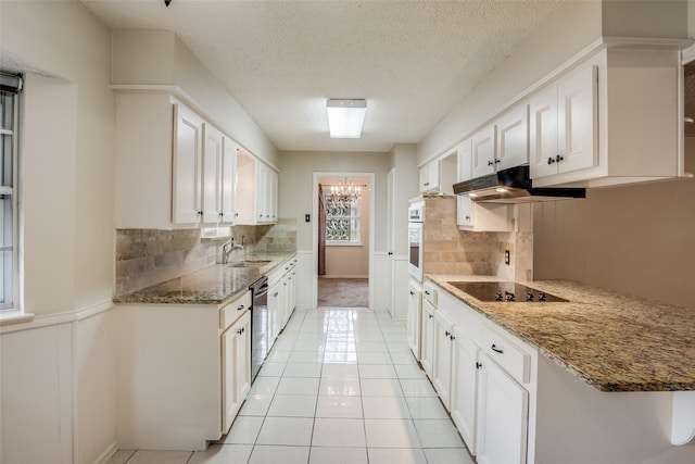 kitchen featuring white cabinets, white oven, black electric cooktop, and sink