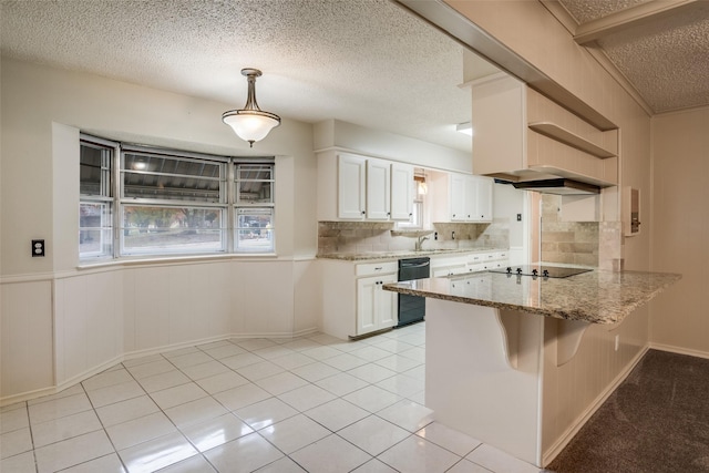 kitchen featuring pendant lighting, black appliances, a textured ceiling, tasteful backsplash, and white cabinetry