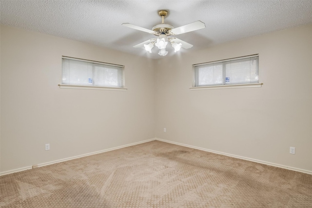 carpeted empty room with a textured ceiling, plenty of natural light, and ceiling fan