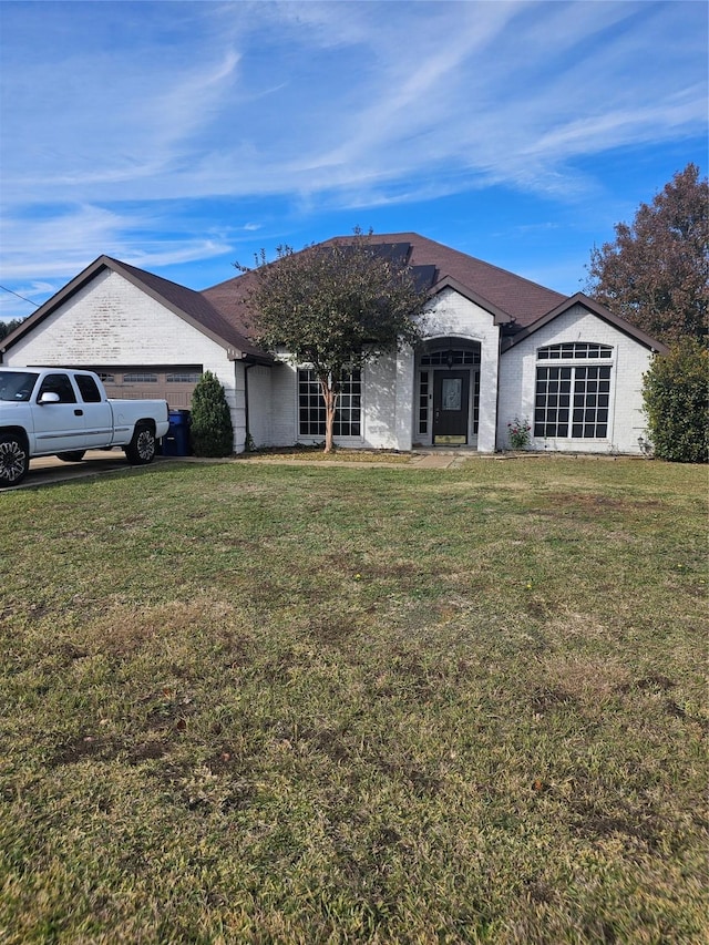 ranch-style house featuring a front yard and a garage