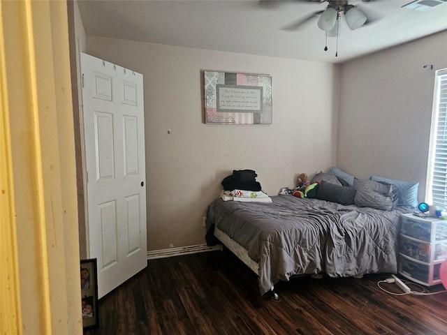 bedroom with dark hardwood / wood-style floors and ceiling fan