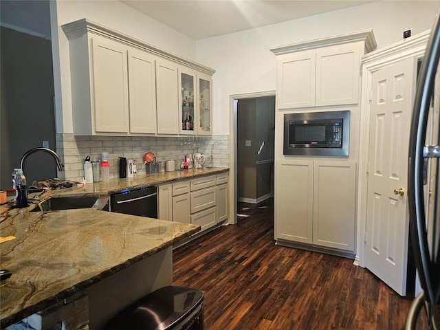 kitchen featuring sink, dark hardwood / wood-style flooring, stone countertops, decorative backsplash, and black appliances