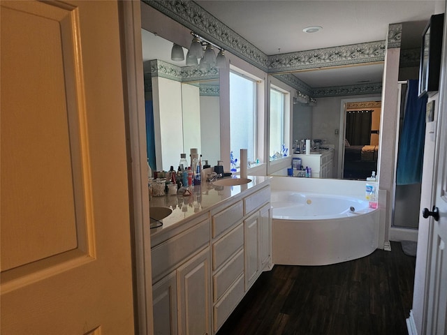 bathroom featuring hardwood / wood-style floors, vanity, and a tub to relax in