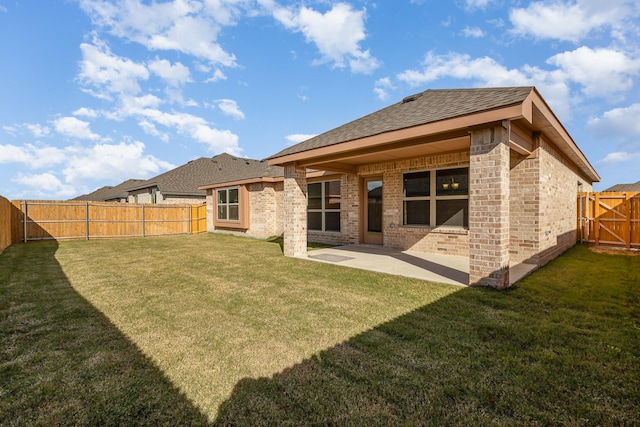 back of property with a yard and a patio area