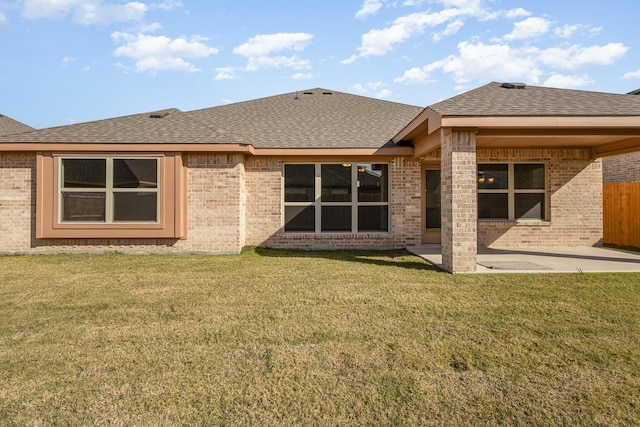 back of property with a lawn and a patio area