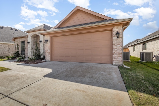 single story home featuring cooling unit, a garage, and a front yard