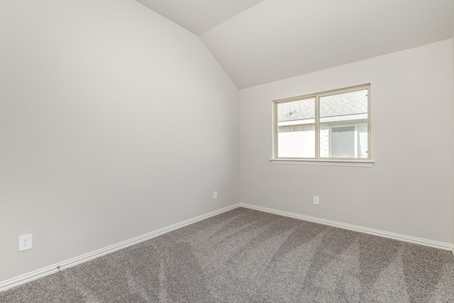 carpeted spare room featuring lofted ceiling