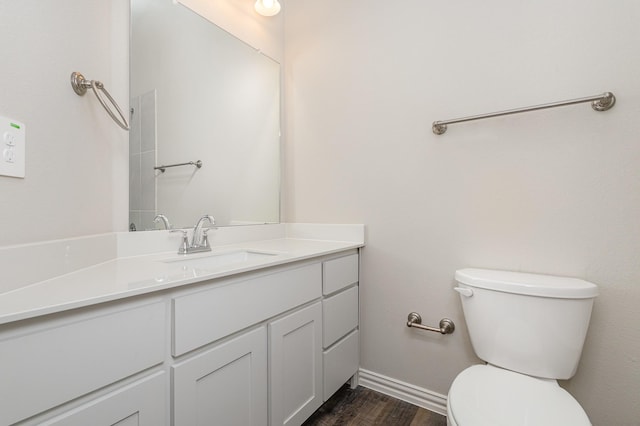 bathroom featuring wood-type flooring, vanity, and toilet