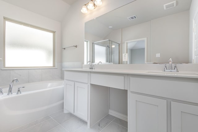 bathroom featuring plus walk in shower, vanity, vaulted ceiling, and tile patterned flooring