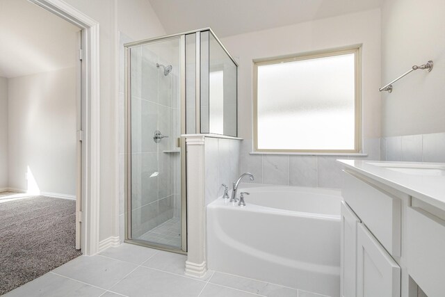 bathroom with tile patterned flooring, vanity, independent shower and bath, and vaulted ceiling