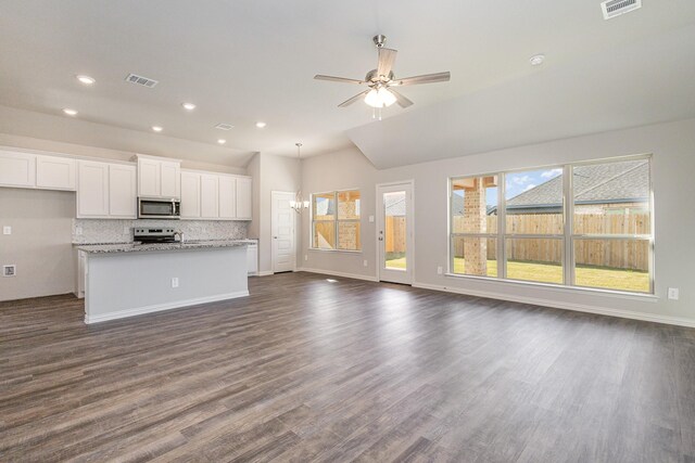 kitchen featuring light stone counters, dark hardwood / wood-style floors, an island with sink, white cabinets, and appliances with stainless steel finishes