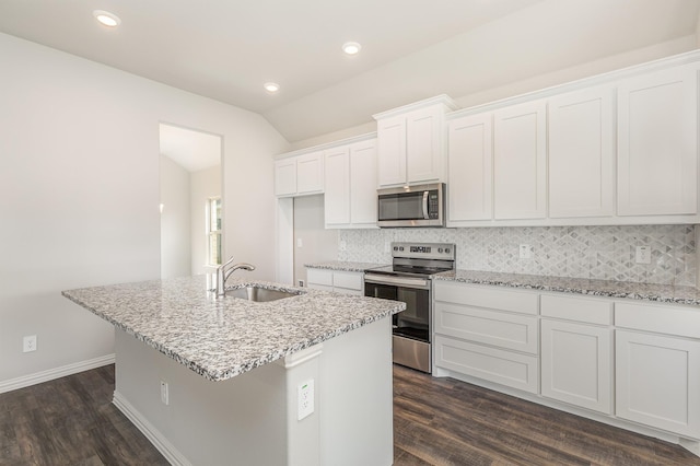 kitchen with appliances with stainless steel finishes, sink, white cabinets, dark hardwood / wood-style floors, and an island with sink