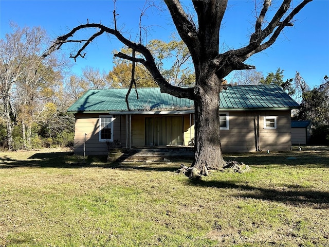 rear view of property featuring a yard