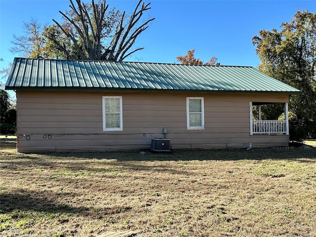 view of side of home with a lawn and central air condition unit