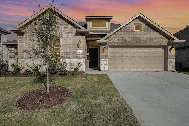 view of front of property with a garage and a yard