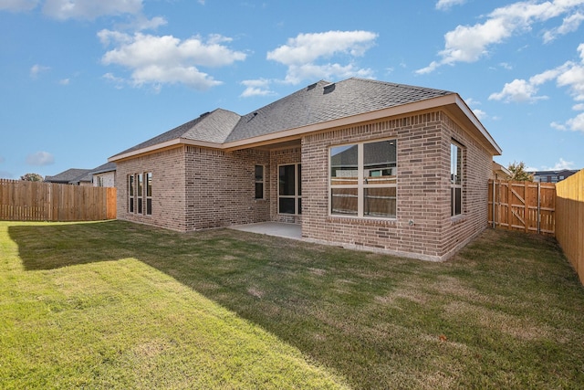 rear view of property with a yard and a patio