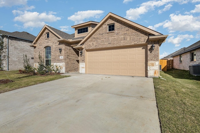 view of front of property featuring a front yard, central AC unit, and a garage