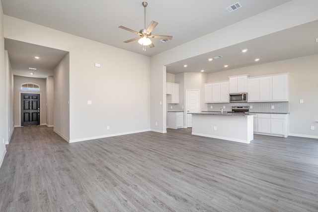 unfurnished living room featuring ceiling fan and light wood-type flooring