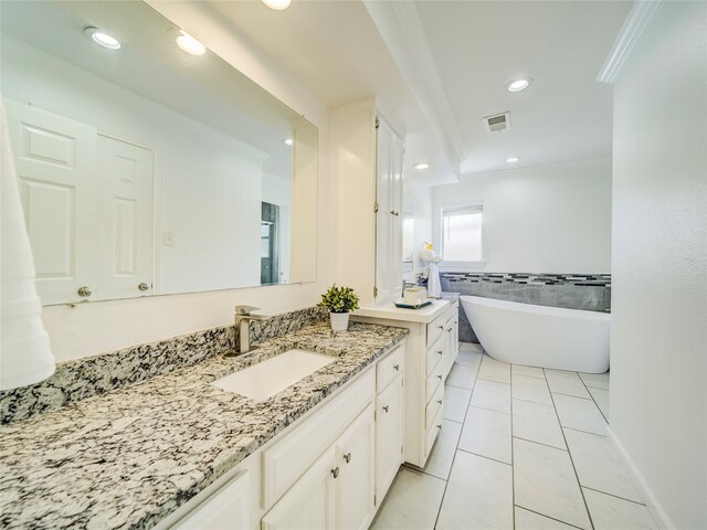 bathroom featuring tile patterned flooring, vanity, a bathtub, and ornamental molding