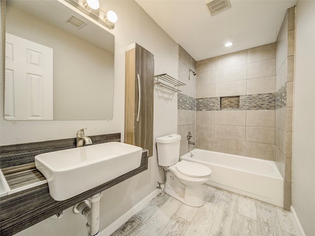 bathroom with toilet, tiled shower / bath combo, and hardwood / wood-style flooring