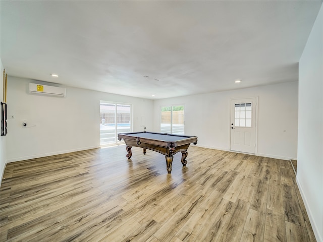 rec room featuring an AC wall unit, pool table, and light hardwood / wood-style flooring