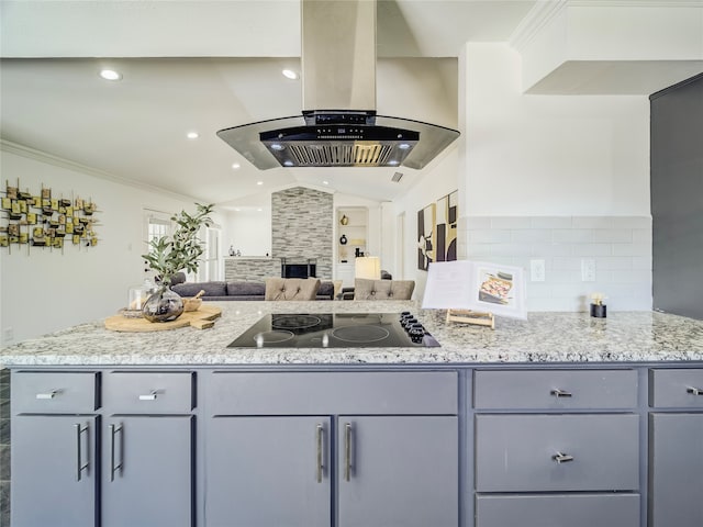 kitchen featuring island exhaust hood, light stone counters, black electric stovetop, and vaulted ceiling