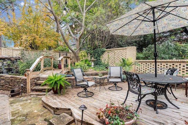 wooden terrace featuring outdoor dining area and fence