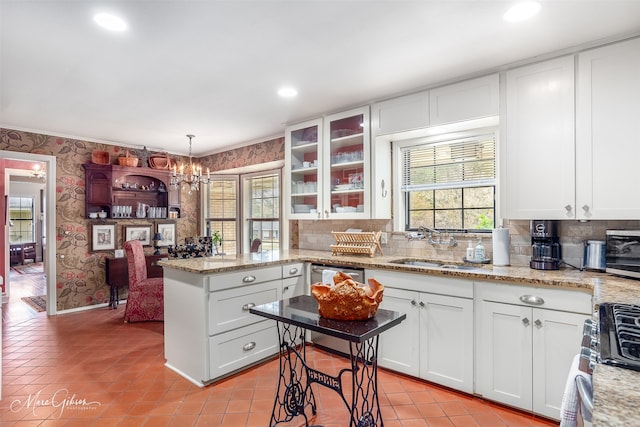 kitchen with stainless steel appliances, white cabinets, wallpapered walls, glass insert cabinets, and pendant lighting