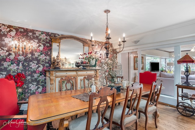 dining area with a notable chandelier, crown molding, and light wood-style flooring