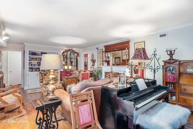 living area featuring light wood-style floors, visible vents, and crown molding