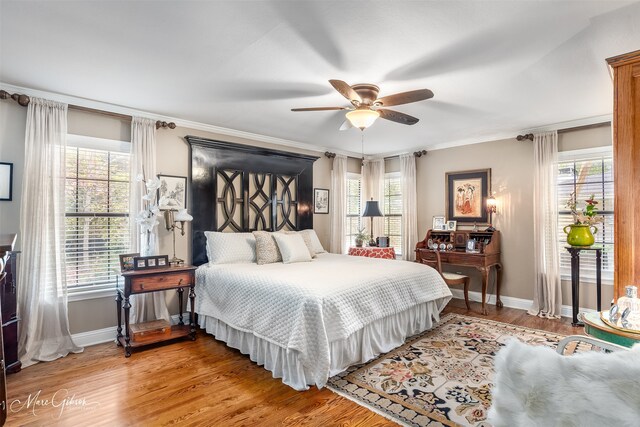 bedroom featuring ceiling fan, dark hardwood / wood-style flooring, and multiple windows