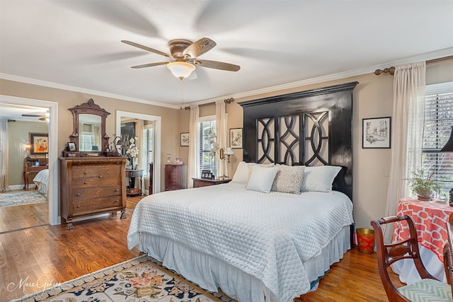 bedroom with dark wood-style floors, multiple windows, and crown molding