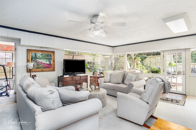 living room featuring a textured ceiling, a ceiling fan, and a healthy amount of sunlight