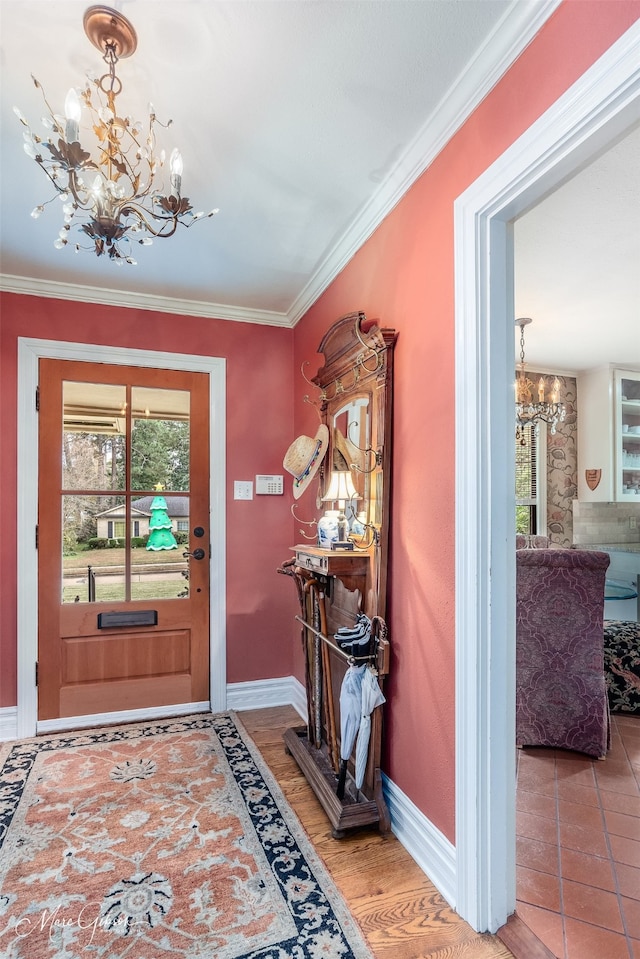 entryway featuring ornamental molding, plenty of natural light, baseboards, and an inviting chandelier