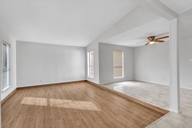 unfurnished living room with ceiling fan, vaulted ceiling, and light wood-type flooring