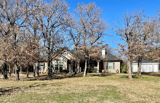 view of front of house with a front lawn and an outdoor structure