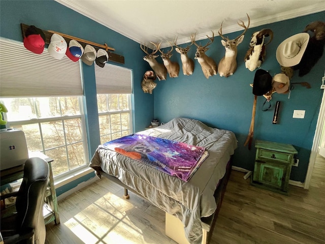 bedroom featuring wood-type flooring and ornamental molding