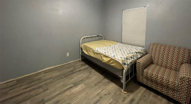 bedroom with dark hardwood / wood-style flooring