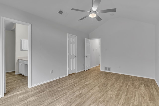 unfurnished bedroom with light wood-style floors, baseboards, visible vents, and vaulted ceiling