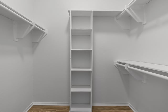 spacious closet with dark wood-style floors