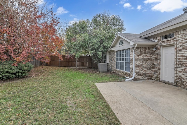 view of yard featuring a patio, central AC unit, and fence