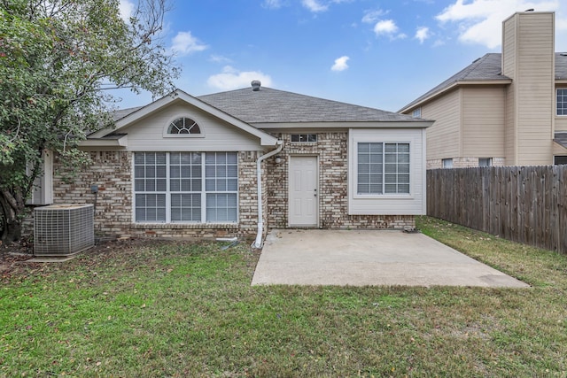 view of front of home with brick siding, a lawn, a patio area, and cooling unit