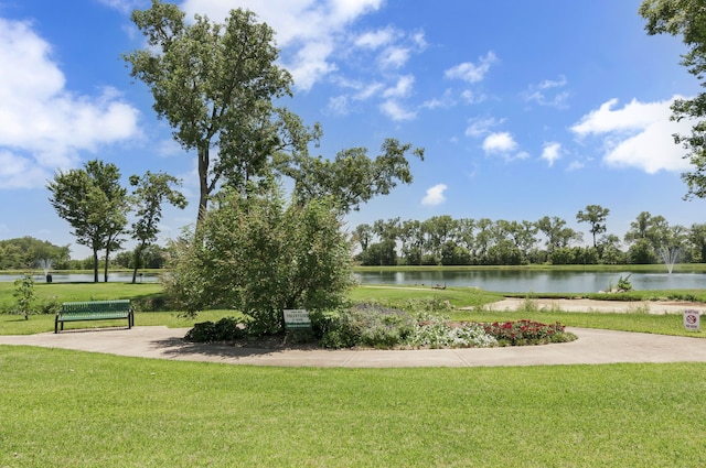 view of property's community with a water view and a yard