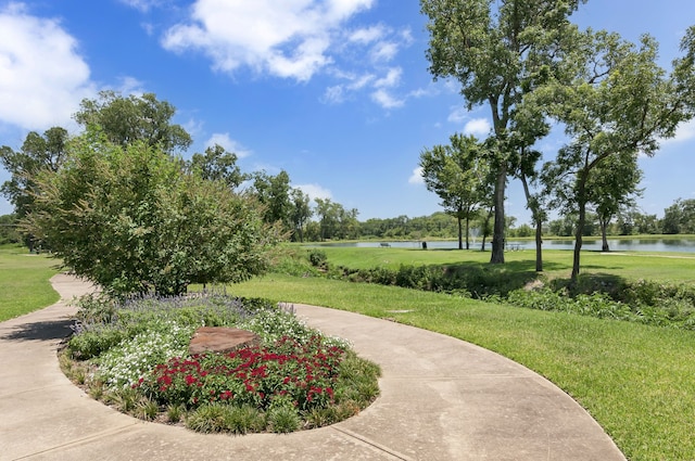 surrounding community with a lawn and a water view