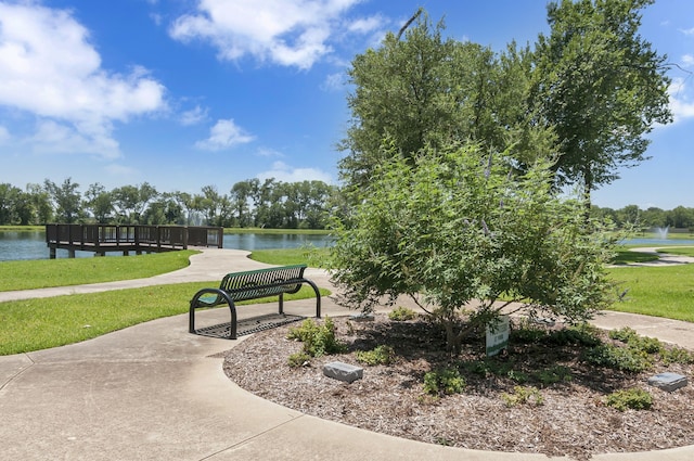 view of home's community with a water view and a yard