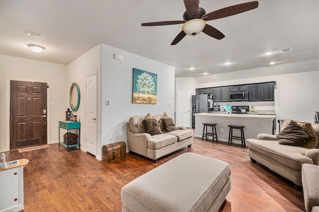 living room featuring ceiling fan and dark wood-type flooring